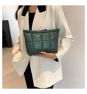 Détail du sac en satin matelassé vert foncé avec texture douce et motif à carreaux