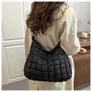 Gros plan du sac fourre-tout noir matelassé avec motif classique de carrés