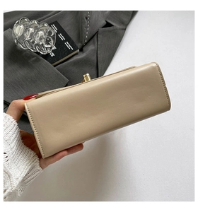 Dettaglio della piccola borsa quadrata in pelle beige con chiusura in metallo dorato a scatto