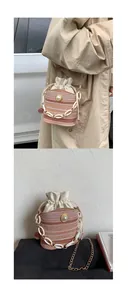 Detailed view of woven bucket bag with white pearl, chain strap, and drawstring liner