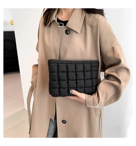Detailansicht der schwarzen gesteppten Clutch mit Karomuster und weicher Haptik