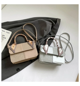 Detailed view of fashionable patchwork square bags with silk scarf wrapped top handles