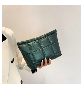 Détail d'une pochette matelassée vert foncé avec motif à carreaux et texture moelleuse