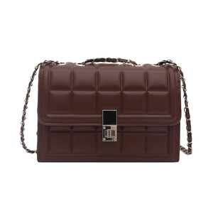 Detail of dark brown quilted crossbody bag featuring silver square twist lock and chain strap