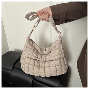 Détail du sac cabas matelassé beige montrant la texture bouffante et les coutures nylon