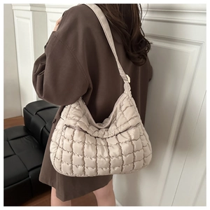 Détail du sac cabas beige matelassé montrant la texture en nylon et la bandoulière