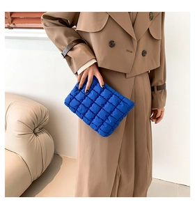 Detail der gesteppten Puffer-Clutch in Klein-Blau mit quadratischer Textur am Modell