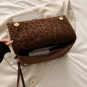 Dettagli interni della borsa leopardata con chiusura magnetica dorata e cinturino a polso