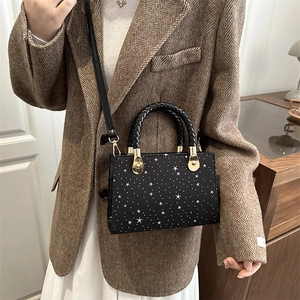 Chic black star print crossbody bag with woven handle for women on a textured blazer