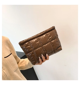 Détail d'une pochette en nylon marron foncé matelassé avec design gaufré rembourré