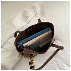 Macro shot of large brown leather tote interior storage with silk scarf detail