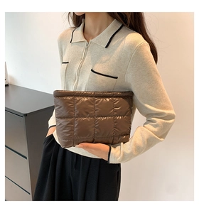 Gros plan d'une pochette matelassée marron foncé avec finition métallique et texture rembourrée