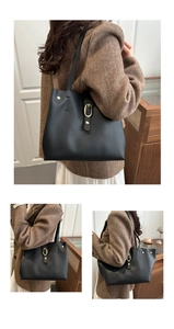 Détails du grand sac cabas noir en cuir avec boucle dorée sur un manteau marron