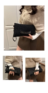 Detalle de bolso de mano con estampado de leopardo negro, remaches dorados y correa