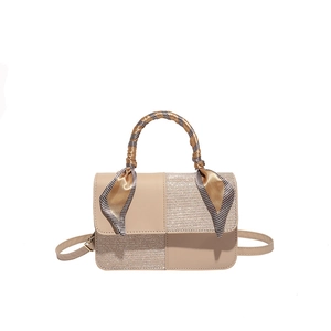 Minimalist beige crossbody bag with silk scarf handle and textured patchwork design