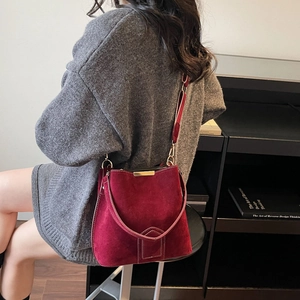 Elegant burgundy suede bucket bag for women featuring gold hardware and a leather strap