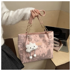 Detailed view of pink tote bag with star patterns and a cute plush cloud pendant