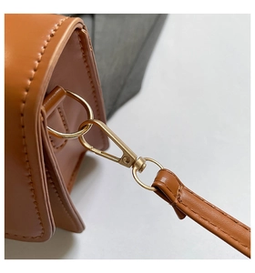 Detail of brown leather texture with high-quality gold lobster clasp and fine stitching