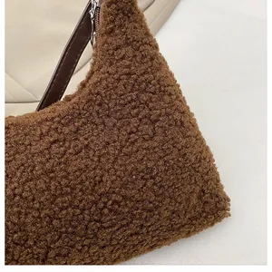 Nahaufnahme der weichen braunen Plüschstruktur und des Lederriemens dieser Wintertasche
