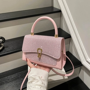 Borsa rosa in pelle con patta glitterata e chiusura a U dorata su sfondo geometrico