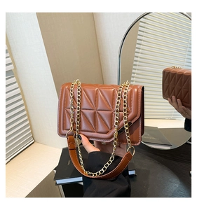 Detailed close-up of brown geometric quilted handbag with elegant gold chain strap