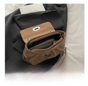 Detail view of the spacious pleated crossbody bag interior with silver chain strap
