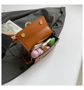 Detail of brown PU leather crossbody bag showing internal capacity with magnetic closure