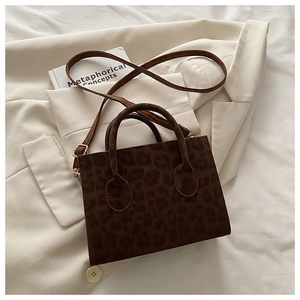 Détail du sac à main chic à motif léopard posé sur un blazer blanc élégant