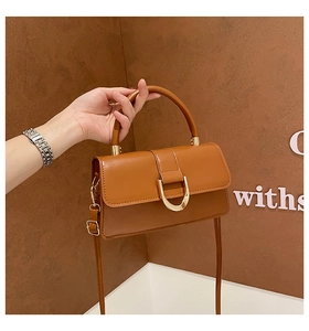 Detail view of a brown vintage tote bag with gold D-shaped buckle and fine leather texture