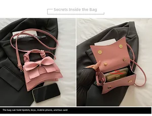 Detail van de interne capaciteit en roze striksluiting van deze compacte crossbody tas