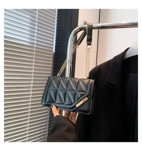 Macro detail of black quilted leather with geometric pattern and gold metallic accents