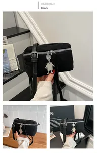 Détail du sac bandoulière noir en simili daim avec un pendentif robot argenté