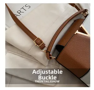 Detail of color-block leather bag with golden V-logo and adjustable buckle strap