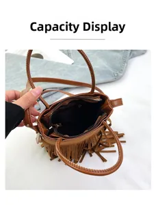 Detail view of the brown fringe bucket bag's interior capacity and zip pocket