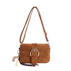Brown suede shoulder bag with gold circular buckle and decorative charm on white background