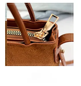 Close-up of smooth gold zipper and texture on brown suede bohemian bucket bag