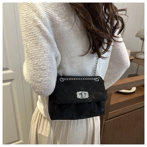 Détail du sac à bandoulière en satin noir avec boucle en cristal et chaîne argentée