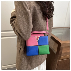 Detail of multi-color crossbody bag with lychee texture and golden V-shaped metal buckle
