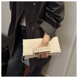 Dettaglio della pochette a busta leopardata con cinturino decorato da borchie