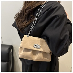 Detail view of khaki pleated chain bag with rhinestone lock buckle on model