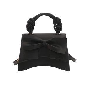 Elegant black ribbon handbag with twisted handle and curved base in matte leather finish