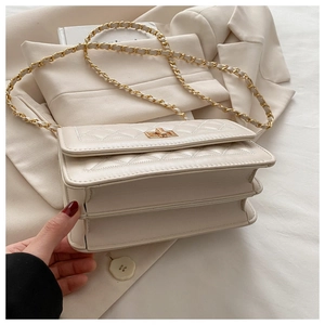Detail of quilted beige chain bag featuring double-layered structure and gold turn-lock