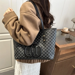 Detailed shoulder view of a large PU leather tote bag with M-letter monogram and round logo