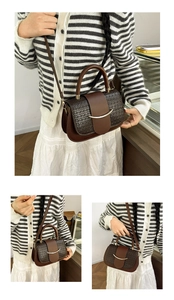 Detail of a brown crocodile texture crossbody bag with gold metal clasp on a female model