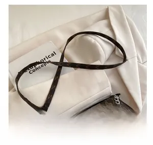 Détails du sac bandoulière marron avec imprimé lettres, chaîne argentée et sangle en cuir