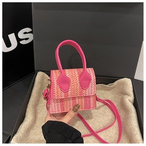 Detail of pink and orange woven mini crossbody bag inside a luxury gift box