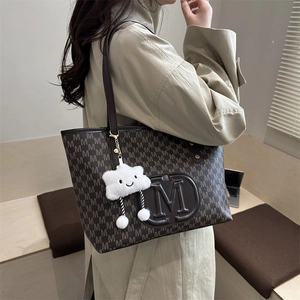 Detail of PU tote bag with M-monogram print, leather logo and plush cloud charm