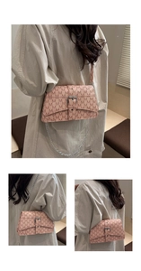 Détails d'un sac bandoulière rose à monogramme avec boucle en métal et bandoulière chaîne