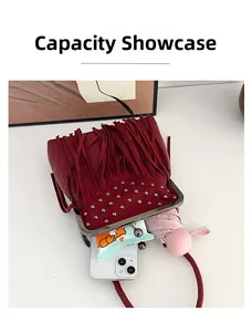 Internal capacity view of dark red tassel bag showing phone and folding umbrella inside