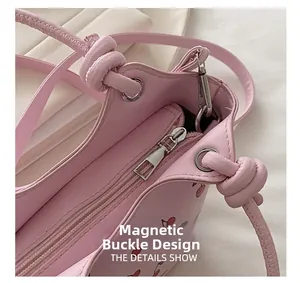 Detail view of pink cherry tote bag featuring secure magnetic closure and metal zipper pocket